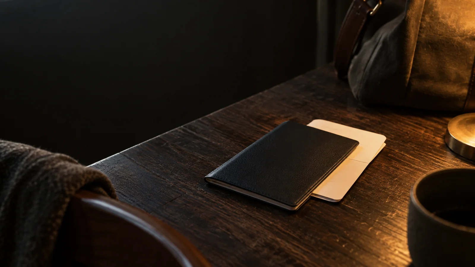 Illustration of a blank travel document and a folded card on a wooden table.